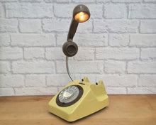 Load image into Gallery viewer, A quirky lamp made from a retro phone. The base of the lamp is a classic mustard rotary phone with a brown-colored dial ring. The brown handset mounted on a flexible gooseneck has a small LED bulb in the receiver converting it into a fabulous lamp.