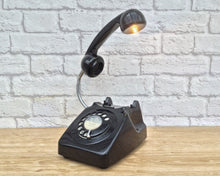 Load image into Gallery viewer, A quirky lamp made from a retro phone. The base of the lamp is a classic black rotary phone with a black dial. The black handset mounted on a flexible gooseneck has a small LED bulb in the receiver converting it into a fabulous lamp.