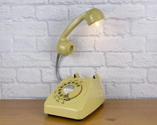 Load image into Gallery viewer, A quirky lamp made from a retro phone. The base of the lamp is a classic mustard rotary phone with a mustard dial & dial ring. The mustard handset mounted on a flexible gooseneck has a small LED bulb in the receiver converting it into a fabulous lamp