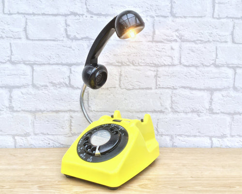 A quirky lamp made from a retro phone. The base of the lamp is a bright yellow rotary phone with a black dial & ring. The black handset mounted on a flexible gooseneck has a small LED bulb in the receiver converting it into a fabulous lamp.