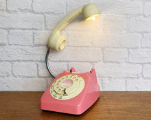 Load image into Gallery viewer, A quirky lamp made from a retro phone. The base of the lamp is a coral pink rotary phone with a cream dial &amp; dial ring. The cream handset mounted on a flexible gooseneck has a small LED bulb in the receiver converting it into a fabulous lamp.
