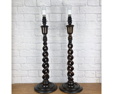 Load image into Gallery viewer, Pair of open barley twist antique wood lamps from the 1930s, standing 24 inches high. Both have matching period bulb holders and have been rewired on brown braided cable and tested. The lamps feature dark brown twisted wooden stems and round bases.
