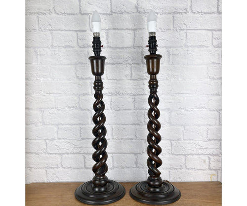 Pair of open barley twist antique wood lamps from the 1930s, standing 24 inches high. Both have matching period bulb holders and have been rewired on brown braided cable and tested. The lamps feature dark brown twisted wooden stems and round bases.